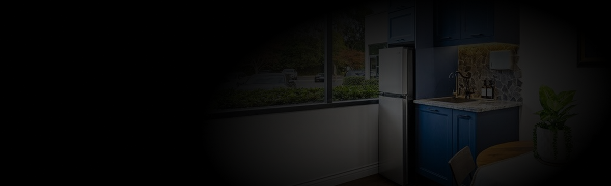Darkly lit kitchen with refrigerator and cabinets - Testosterone Replacement Therapy. 