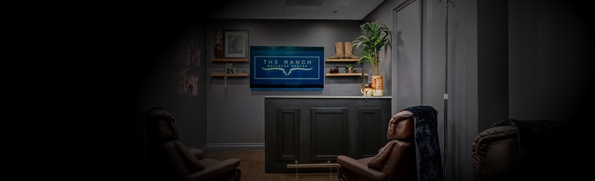Modern living room with a television displaying a blue screen, surrounded by furniture and decor - The Ranch Wellness Center