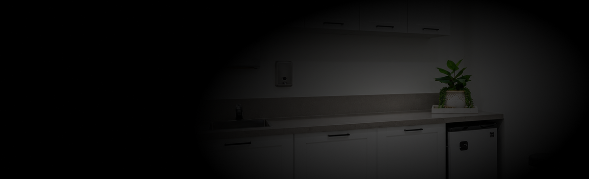 Darkly lit room with a desk and plant
